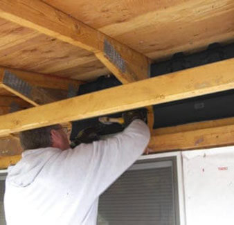 man installing attic baffles in home