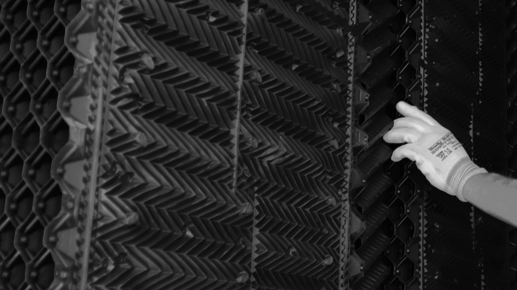 A person wearing gloves touches a textured, zigzag-patterned surface with their right hand. It is the XF75 Pro.