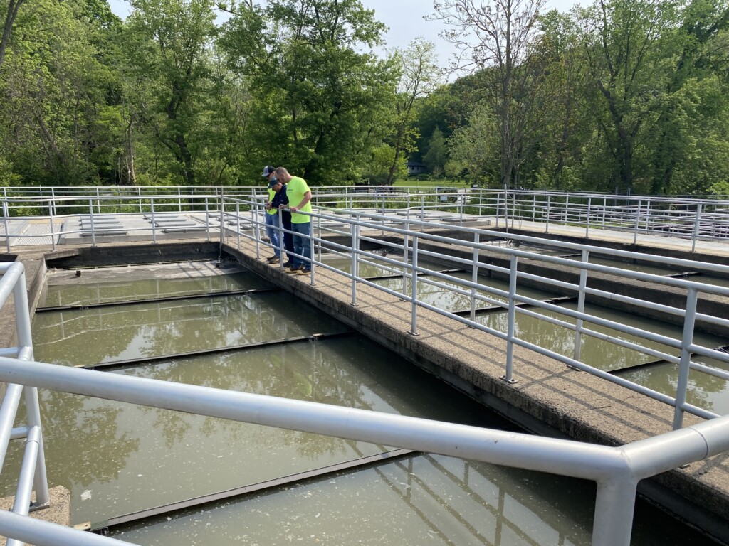 Solutions team members examining a chain and flight system.