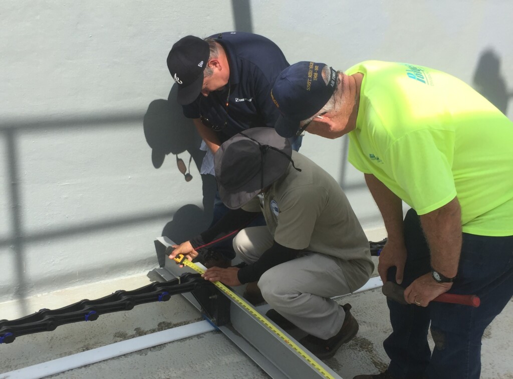 Brentwood Solutions team members measuring a flight scraper in a rectangular clarifier.