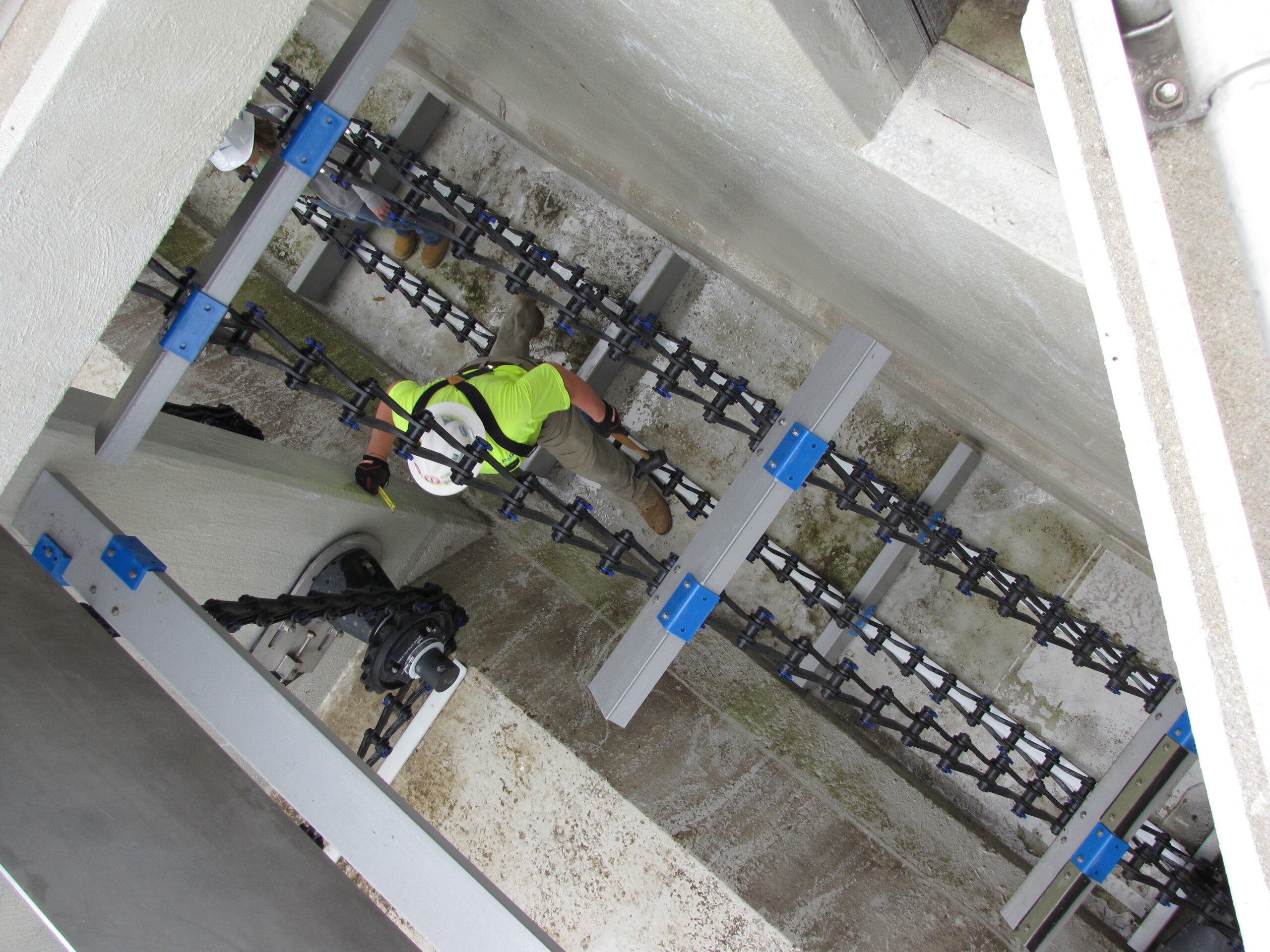 A technician inspecting a Polychem chain and flight system.